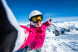 © MayR - Selfie snowboarder. Young happy woman taking selfie with the smartphone on the top of the mountain