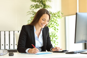 Happy office worker calculating and writing budget