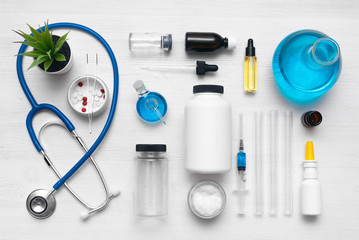 Medical, chemistry or pharmacy background. Laboratory table with a various chemical reagents, stethoscope, syringe and jars abstract background. Flat lay.