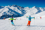 Fototapeta Mapy - Cute skier boy with his mother having fun in a winter ski resort.
