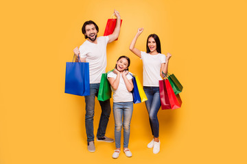 Poster - Full length body size view portrait of nice attractive trendy cheerful people holding in hands bags with new clothes having fun rejoice isolated over shine vivid pastel yellow background