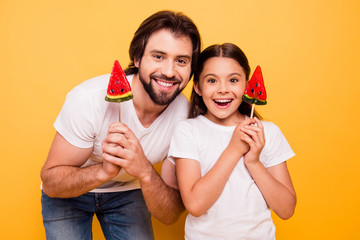 Close-up portrait of nice cute lovely adorable attractive cheerful cheery people dad daddy holding in hands candies isolated over shine vivid pastel yellow background