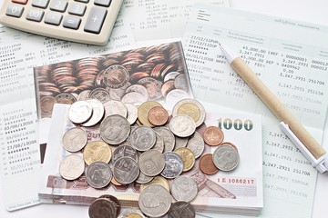 Business, finance, saving money, taxes or accounting concept : Top view or flat lay of coins, cash money, calculator and pen on savings account book or financial statements