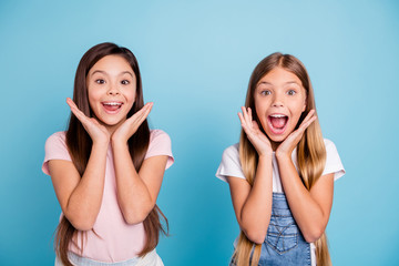 Close-up portrait of two people nice cute attractive charming cheerful glad straight-haired pre-teen girls overjoy great news isolated on blue turquoise background