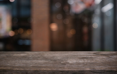 Empty dark wooden table in front of abstract blurred bokeh background of restaurant . can be used for display or montage your products.Mock up for space.