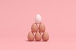 Outstanding white Egg among brown eggs on pink background. minimal Easter idea.