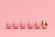 Outstanding Golden Egg among brown eggs on pink background. minimal Easter idea. 3D