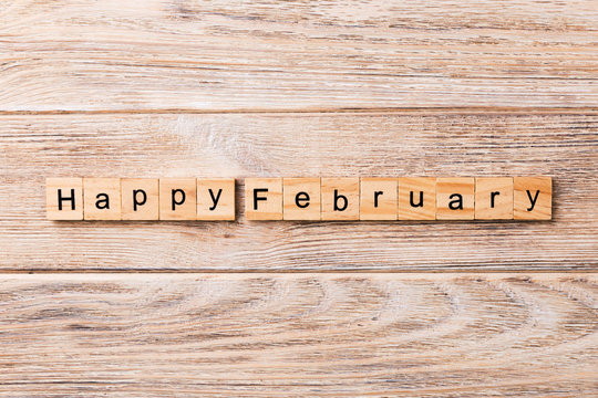Happy February word written on wood block. Happy February text on table, concept