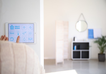 Young woman using application of smart home automation