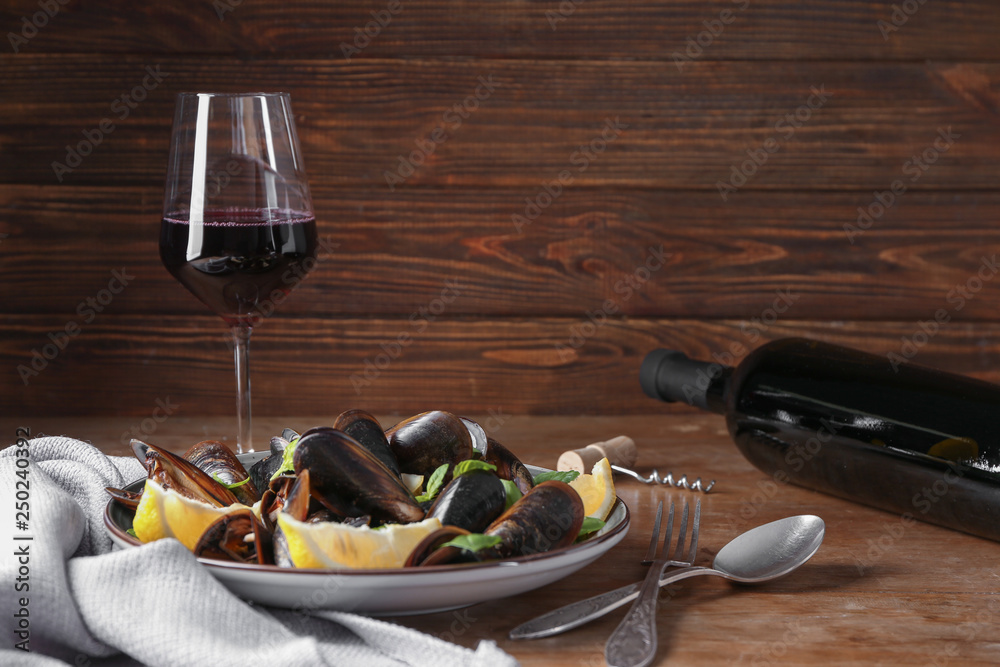 Tasty red wine with mussels on wooden table