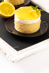 Wall Mural - Food concept Homemade Lemon curd sponge cake with fresh whipped cream in black plate with copy space