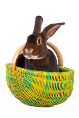 Wall Mural - Brown rabbit in a colorful basket isolated on white