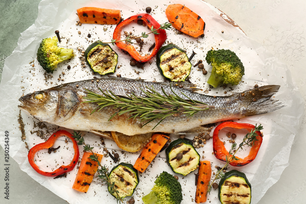 Tasty cooked seabass fish and vegetables on parchment