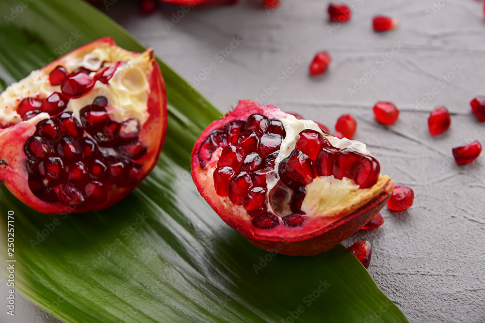 Pieces of ripe pomegranate on grey background