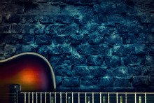 Old Vintage Jazz Guitar On A Brick Wall Background. Copy Space. Background For Concerts, Festivals, Music Schools. Art,