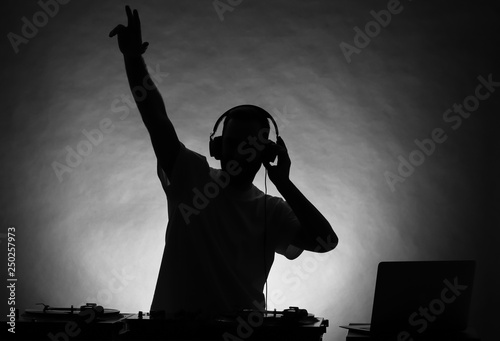 Silhouette of male DJ playing music on grey background Tableau sur Toile