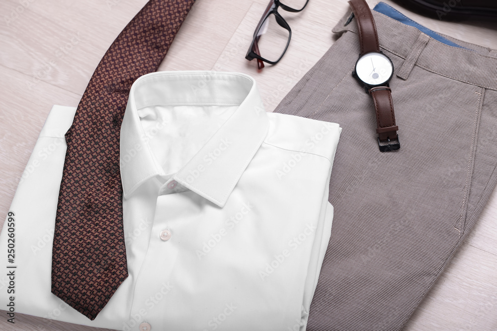 Set of male clothes and accessories on wooden background