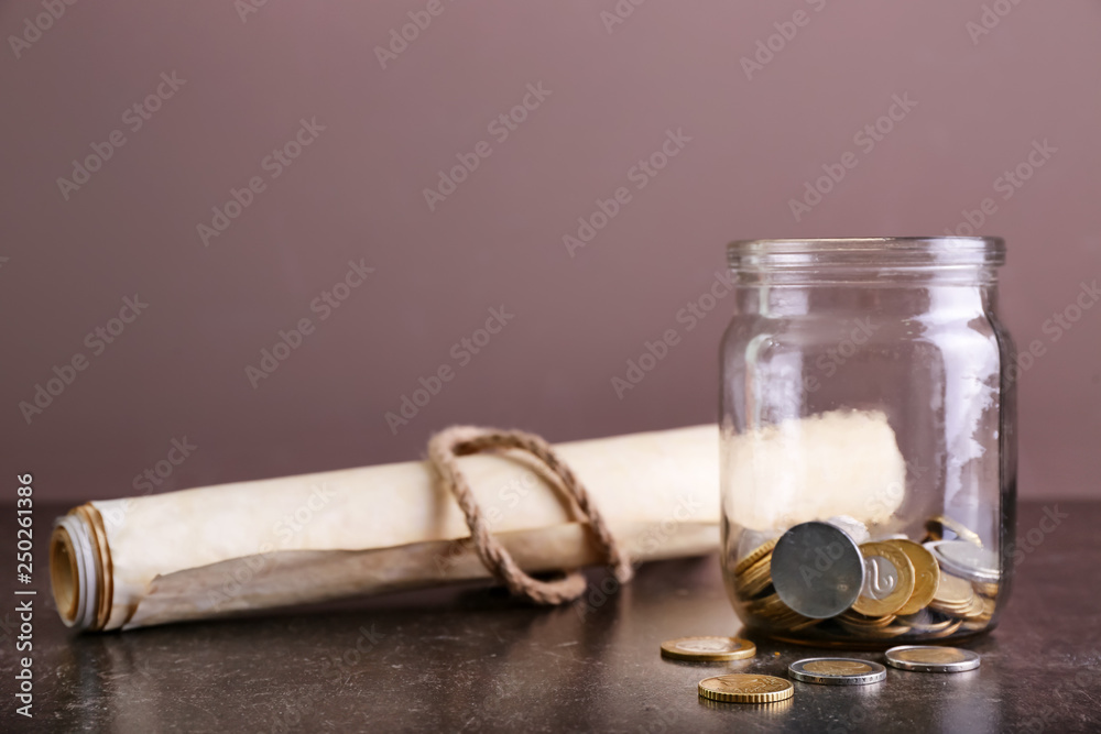 The Scroll of Esther and jar with coins on table. Purim celebration