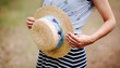 Beautiful woman and boater straw hat with blue decor in summer
