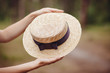 Hands with boater straw hat outdoors, french style fashion