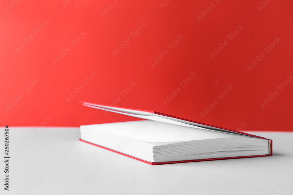 Book on table against color background