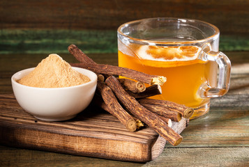 Wall Mural - Licorice cup of tea, powder and roots - Glycyrrhiza glabra. Top view