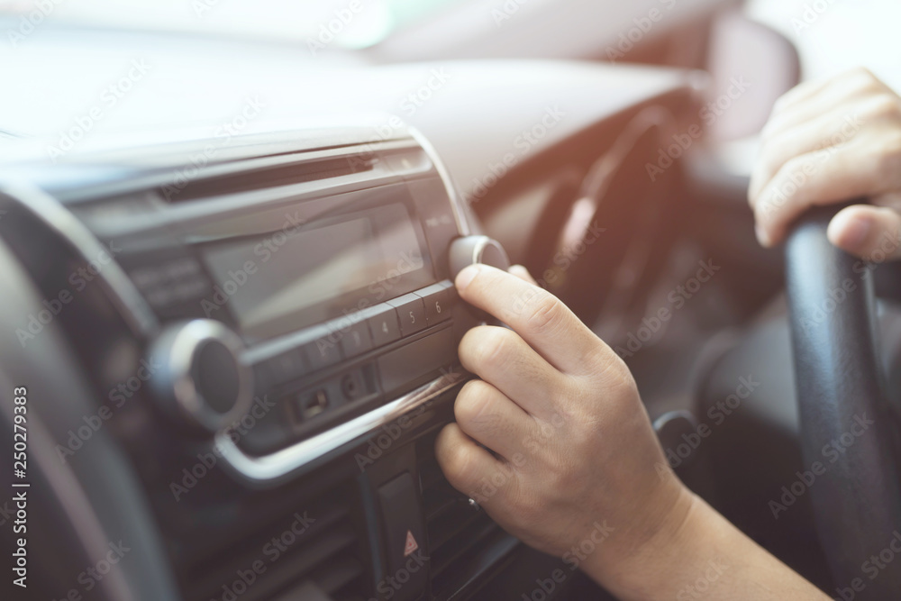 close up hand open car radio listening. Car Driver changing turning button Radio Stations on His Vehicle Multimedia System. Modern touch screen Audio stereo System. transportation and vehicle concept - obrazy, fototapety, plakaty 
