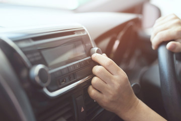 close up hand open car radio listening. Car Driver changing turning button Radio Stations on His Vehicle Multimedia System. Modern touch screen Audio stereo System. transportation and vehicle concept