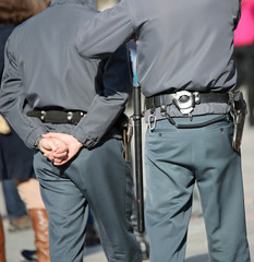 Wall Mural - two policemen on patrol with handcuffs and buggy during the patr