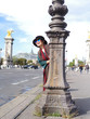 femme et poyeau d'un éclairage public devant le Pont Alexandre 3, Paris