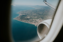 Airplane Engine And Wing, And Costa Del Sol Sea Shore Viewed From A Plane Through The Plane Window, Before Landing.
