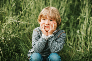 Wall Mural - Candid portrait of adorable little boy of 4-5 years old, wearing blue hoody