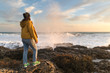© Konstantin Maslak - Young woman standing on the rock enjoying sunset near winter sea. Travel Europe in winter
