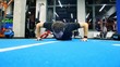 © smartbobert - Young caucasian male athlete in sportswear doing push ups on, people training in gym, man exercising in fitness club.