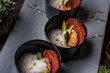 Lobster shrimp appetizer with parma ham, asparagus and white mousse sauce in black bowl on rustic wooden table 