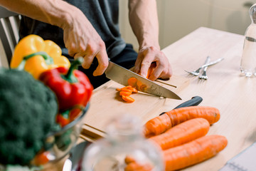 Healthy lifestyle, healthy food. A young man prepares a salad from fresh vegetables and fruits.