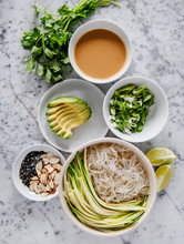 Ingredients For Asian Rice Noodle Dish With Avocado, Parsley, Vegetables, Almonds And Sesame Seeds