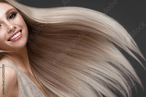Fotomural Beautiful blond girl in move with a perfectly smooth hair, and classic make-up