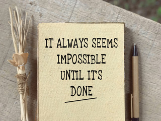 Wall Mural - Motivational and inspirational quote - It always seems impossible until it’s done written on a paper. Blurred styled background.