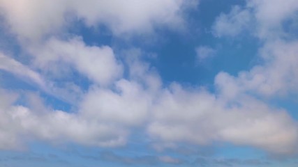 Wall Mural - looping one minute footage features white puffy clouds on a sunny day moving across a deep blue sky.