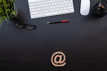 Fototapete - Flat lay of top view modern black wood  desk work table with computer laptop and stationary in home office include @ with space for add email address