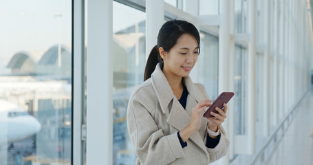 Poster - Woman use of mobile phone in the airport