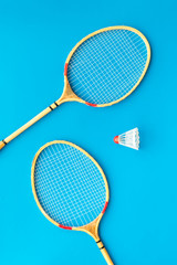 Sticker - Badminton concept. Badminton rackets and shuttlecock on blue background top view pattern