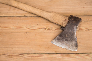 Old ax with a wooden handle stuck in wooden log. Concept for woodworking or deforestation. Selective focus.