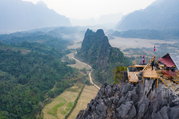 (View from above) Stunning aerial view of some tourists taking pictures at the beautiful panorama from the Nam Xay viewpoint in Vang Vieng, Laos.