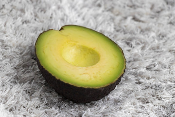 Half green sliced avocado on carpet