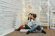 © CRISTINA - Happy couple near a christmas decoration, white background.