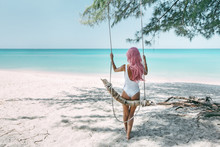 Girl With Pink Hair Hanging On Swing At Beach