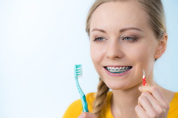 Wall Mural - Woman smiling cleaning teeth with braces