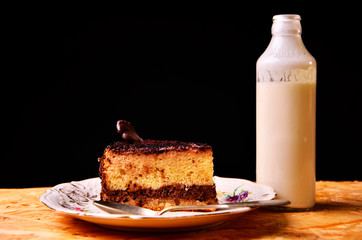 piece of cake with the bottle of milk on the tablecloth